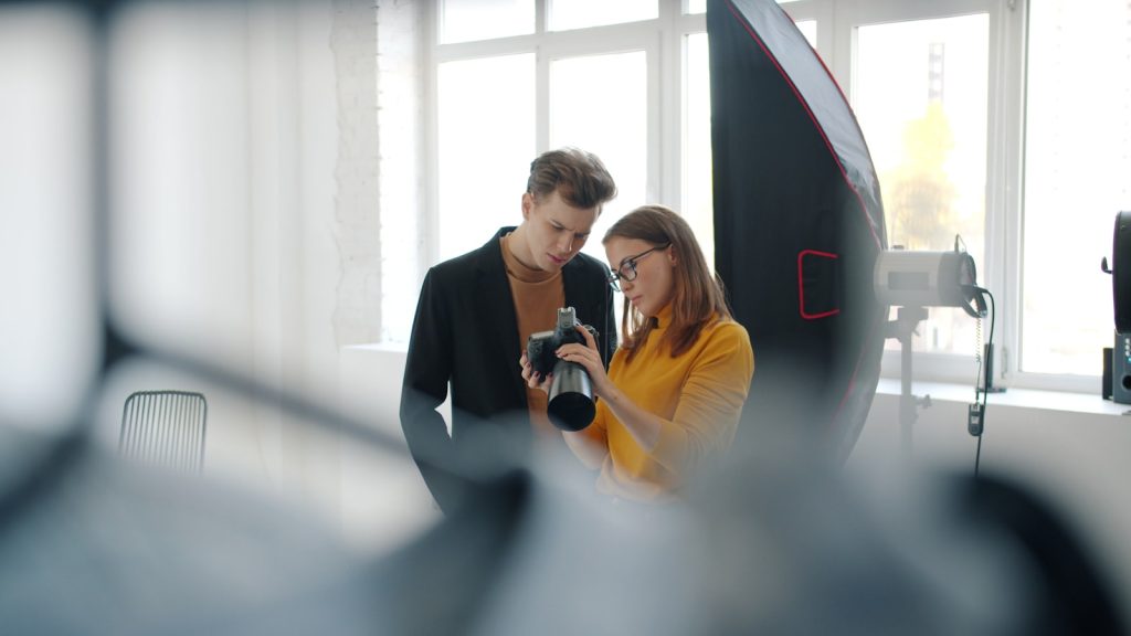 Photographer and client reviewing photos in a studio