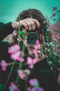 Photographer composing a shot of flowers